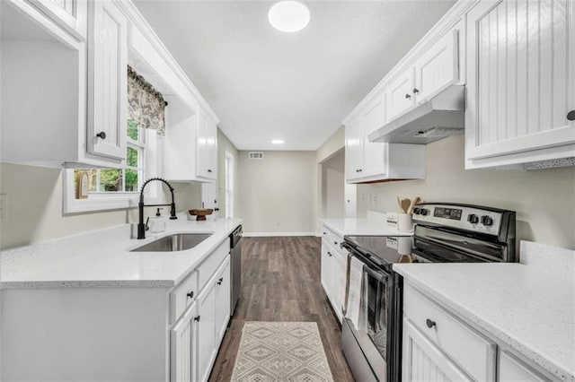 254 Barnesville Rd, Milner, GA 30257 - kitchen with under cabinet range hood, stainless steel appliances, a sink, dark wood-type flooring, and white cabinetry