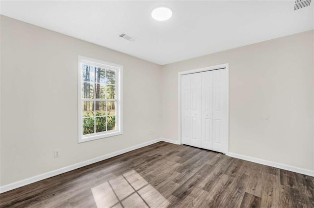 254 Barnesville Rd, Milner, GA 30257 - unfurnished bedroom featuring baseboards, wood finished floors, and visible vents