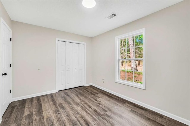 254 Barnesville Rd, Milner, GA 30257 - unfurnished bedroom featuring baseboards, wood finished floors, visible vents, and a closet