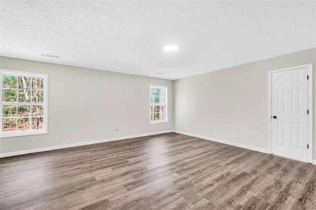 254 Barnesville Rd, Milner, GA 30257 - empty room featuring a textured ceiling, visible vents, baseboards, recessed lighting, and wood finished floors