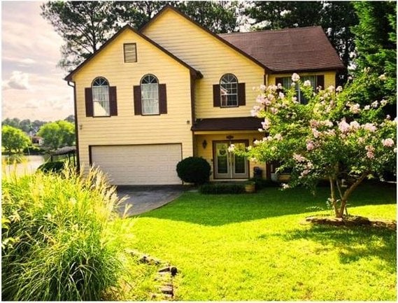 view of front of home featuring a front yard and a garage