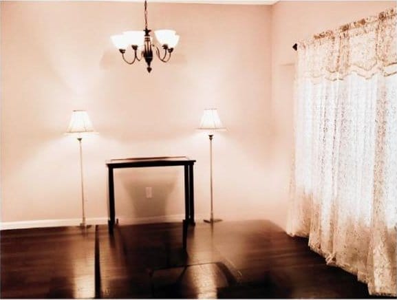 interior space featuring wood-type flooring and an inviting chandelier