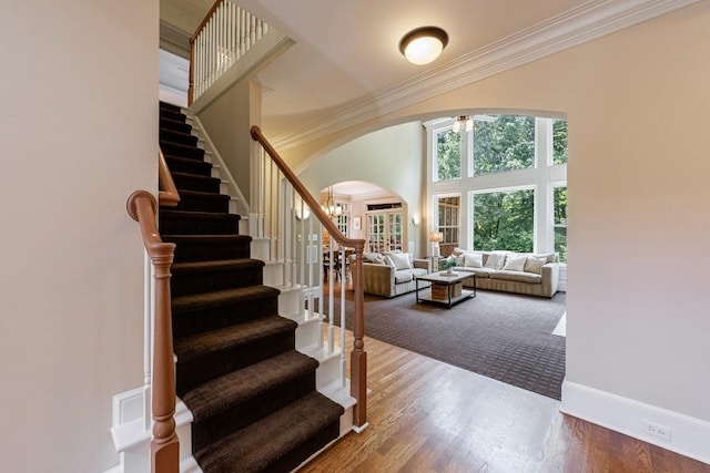 4310 Granby Way, Marietta, GA 30062 - stairs featuring arched walkways, ornamental molding, a towering ceiling, and wood finished floors