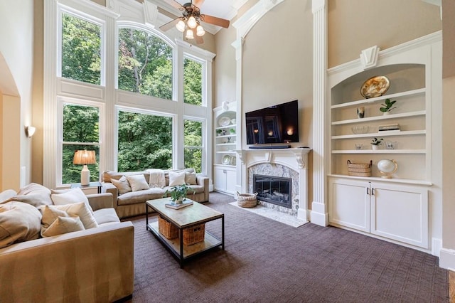 4310 Granby Way, Marietta, GA 30062 - living room featuring a towering ceiling, built in features, ceiling fan, a high end fireplace, and dark colored carpet