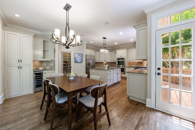 4310 Granby Way, Marietta, GA 30062 - dining space featuring beverage cooler, a chandelier, dark wood finished floors, ornamental molding, and recessed lighting
