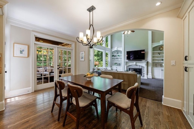 4310 Granby Way, Marietta, GA 30062 - dining space with a chandelier, dark wood-style floors, a fireplace, ornamental molding, and built in shelves
