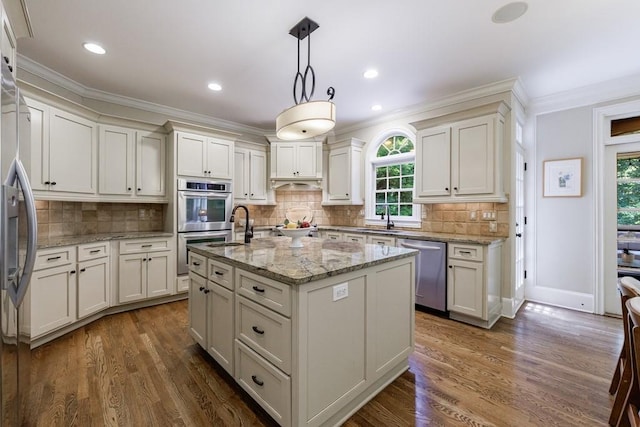 4310 Granby Way, Marietta, GA 30062 - kitchen with appliances with stainless steel finishes, ornamental molding, a kitchen island with sink, dark wood-style floors, and pendant lighting
