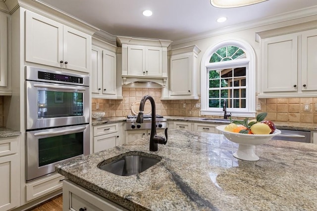 4310 Granby Way, Marietta, GA 30062 - kitchen featuring appliances with stainless steel finishes, crown molding, decorative backsplash, light stone counters, and recessed lighting