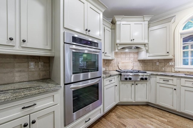 4310 Granby Way, Marietta, GA 30062 - kitchen featuring appliances with stainless steel finishes, backsplash, white cabinets, light wood finished floors, and crown molding