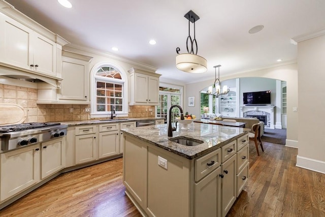 4310 Granby Way, Marietta, GA 30062 - kitchen featuring stainless steel appliances, a fireplace, crown molding, light stone counters, and tasteful backsplash
