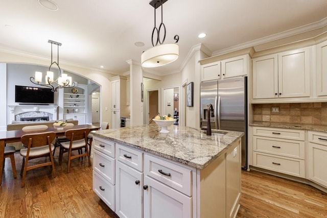 4310 Granby Way, Marietta, GA 30062 - kitchen with a center island, ornamental molding, arched walkways, light wood finished floors, and light stone counters