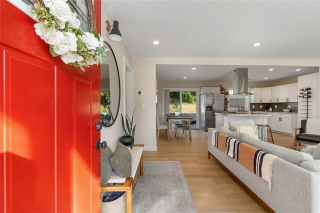 living area with recessed lighting, baseboards, and light wood finished floors