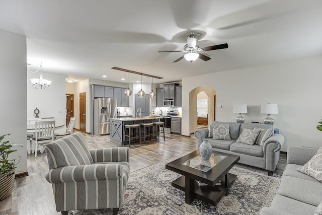 893 Whitfield Oak Rd, Auburn, GA 30011 - living area with arched walkways, ceiling fan, light wood-type flooring, and a chandelier