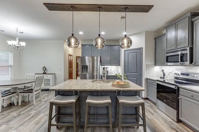 893 Whitfield Oak Rd, Auburn, GA 30011 - kitchen with stainless steel appliances, light wood-style floors, tasteful backsplash, gray cabinetry, and light stone countertops