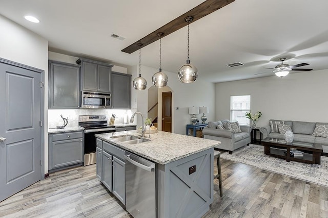 893 Whitfield Oak Rd, Auburn, GA 30011 - kitchen featuring appliances with stainless steel finishes, a sink, gray cabinetry, arched walkways, and open floor plan