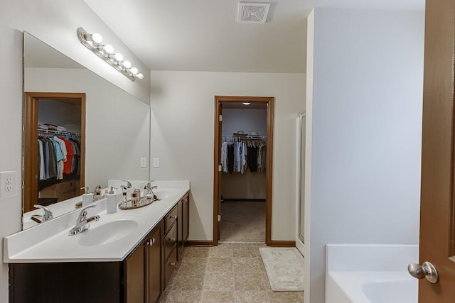893 Whitfield Oak Rd, Auburn, GA 30011 - full bath featuring double vanity, a spacious closet, a garden tub, and baseboards