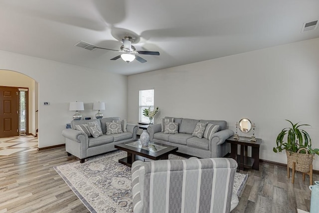 893 Whitfield Oak Rd, Auburn, GA 30011 - living area with arched walkways, light wood-style floors, a ceiling fan, and baseboards