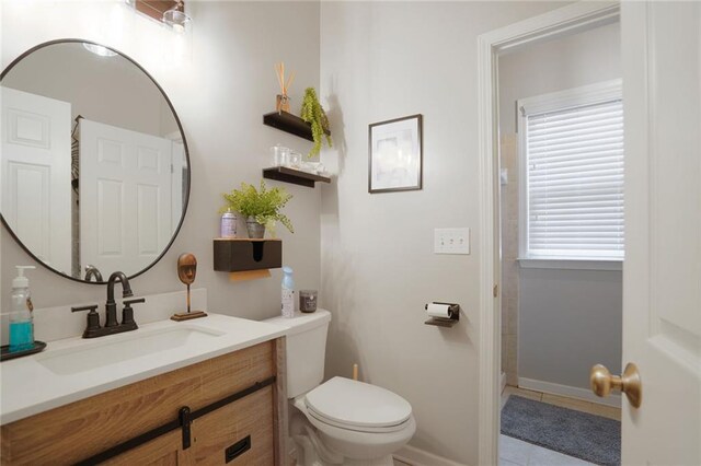 bathroom with toilet, tile patterned flooring, baseboards, and vanity