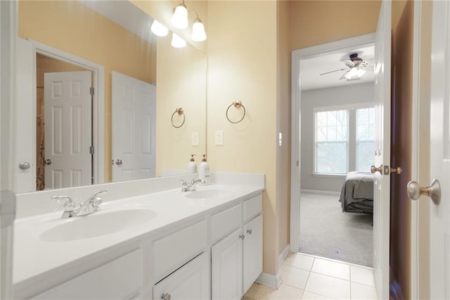 bathroom with a ceiling fan, baseboards, a sink, and double vanity