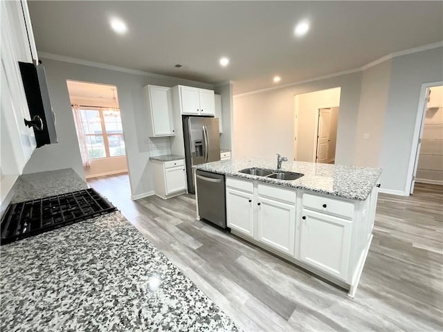 kitchen with crown molding, light wood finished floors, stainless steel appliances, white cabinets, and a sink