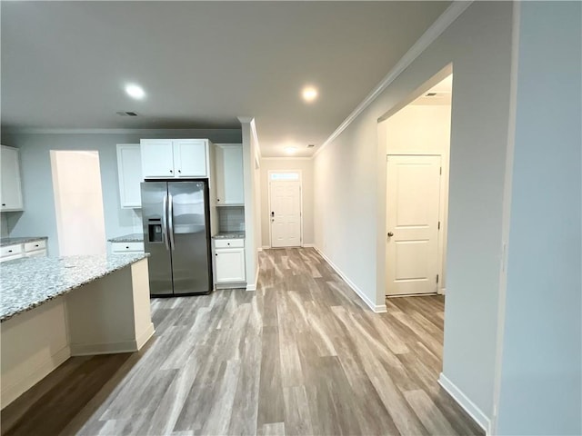 kitchen featuring light wood-style floors, white cabinets, stainless steel refrigerator with ice dispenser, and light stone countertops