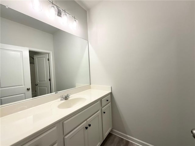 bathroom featuring vanity, baseboards, and wood finished floors