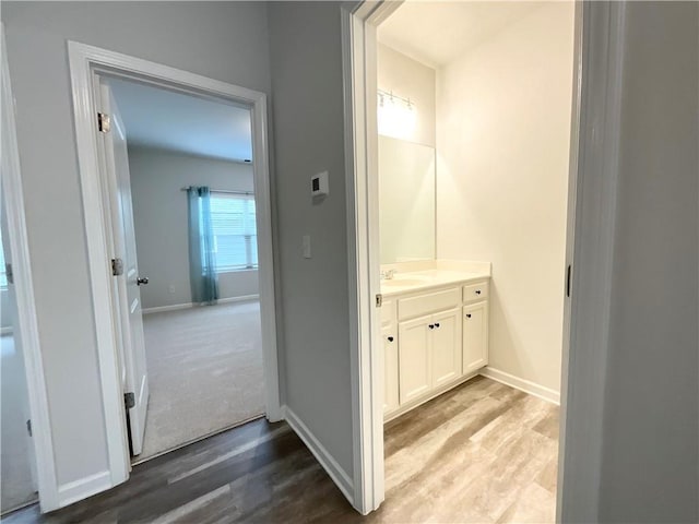 bathroom with vanity, baseboards, and wood finished floors