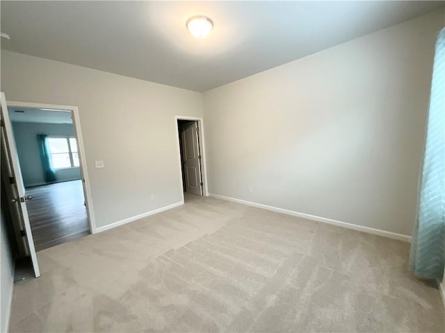 unfurnished bedroom with light carpet and baseboards