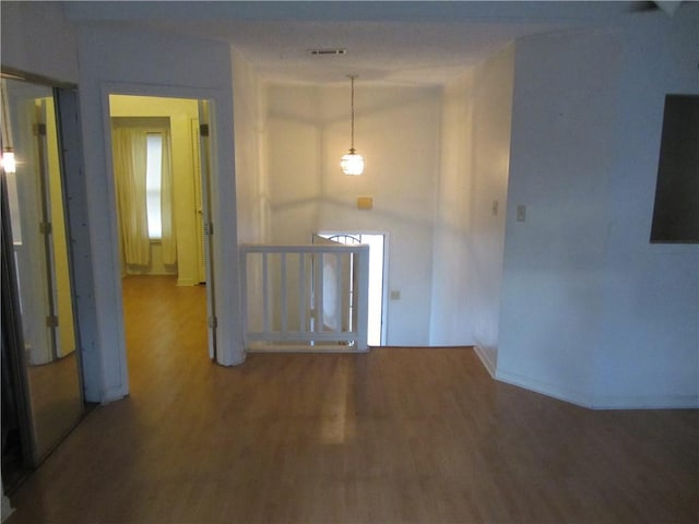 interior space with visible vents, an upstairs landing, and wood finished floors