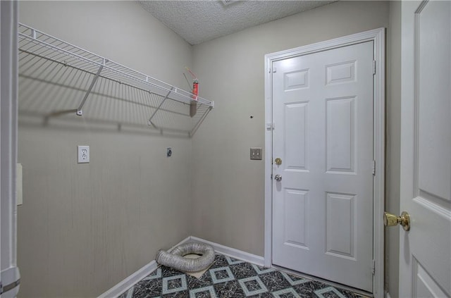 laundry area featuring hookup for an electric dryer and a textured ceiling