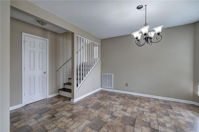 interior space featuring a notable chandelier and a textured ceiling