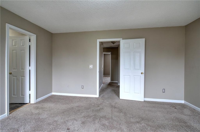 empty room featuring light carpet and a textured ceiling