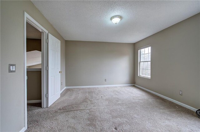 carpeted empty room with a textured ceiling