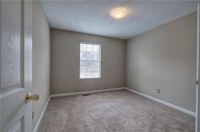 carpeted empty room with a textured ceiling