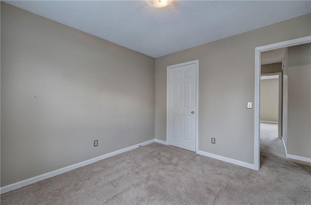 unfurnished bedroom with light colored carpet and a textured ceiling