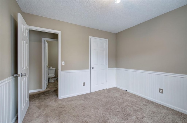 unfurnished bedroom with light carpet and a textured ceiling