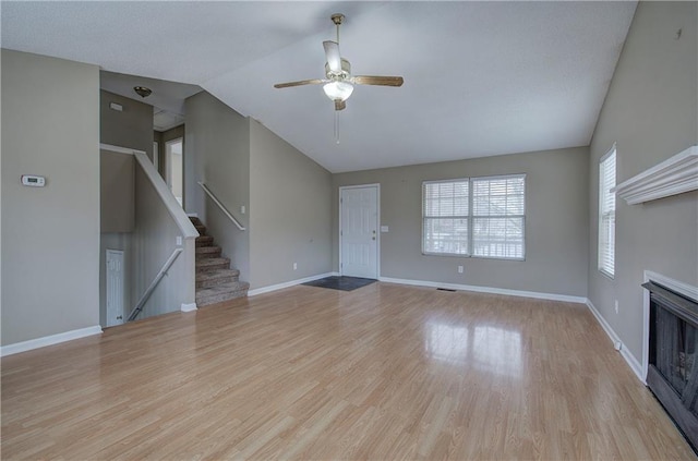 unfurnished living room with ceiling fan, lofted ceiling, and light hardwood / wood-style floors