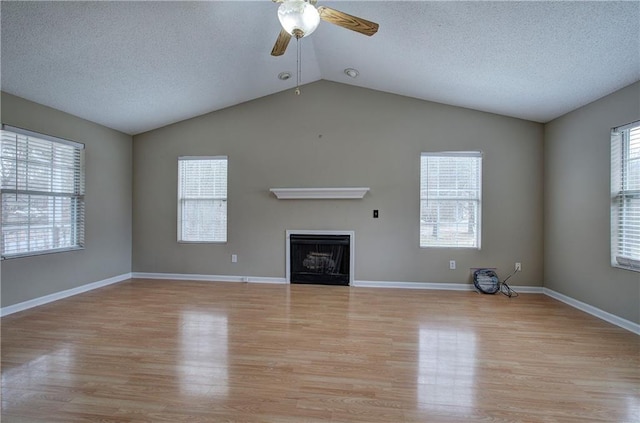 unfurnished living room with lofted ceiling, plenty of natural light, and light hardwood / wood-style flooring