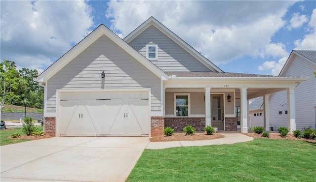 view of front of property featuring covered porch, a front yard, and a garage