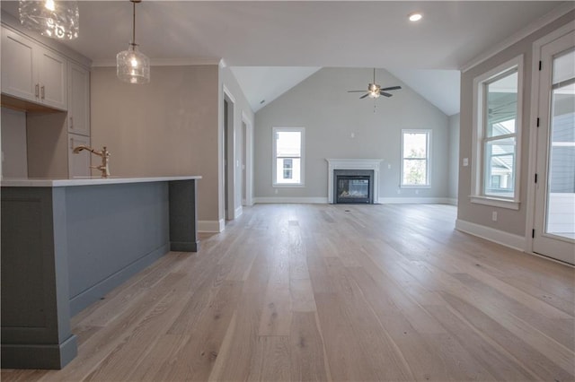 unfurnished living room featuring ceiling fan, lofted ceiling, and light wood-type flooring