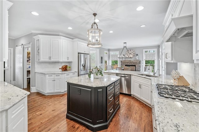 7025 Windsor Hill Psge, Suwanee, GA 30024 - kitchen featuring stainless steel appliances, crown molding, white cabinets, recessed lighting, and a stone fireplace