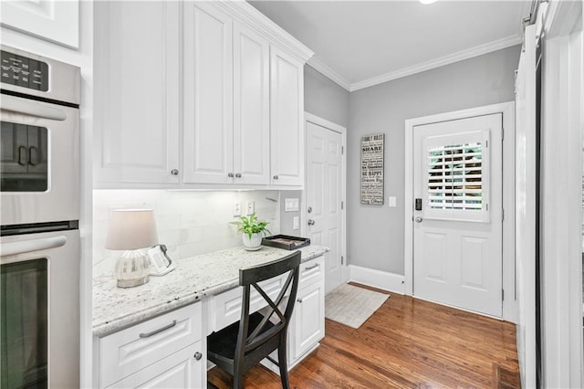 7025 Windsor Hill Psge, Suwanee, GA 30024 - home office featuring built in study area, crown molding, and dark wood finished floors