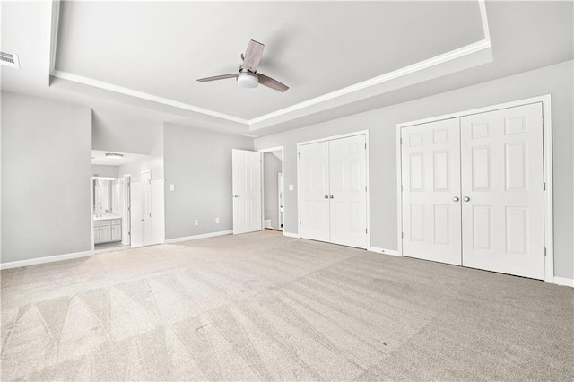 7025 Windsor Hill Psge, Suwanee, GA 30024 - unfurnished bedroom with a tray ceiling, two closets, carpet floors, connected bathroom, and ornamental molding