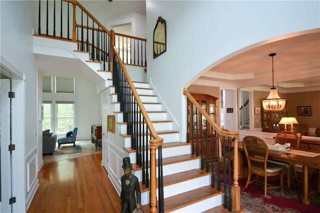 2637 Morningside Trl NW, Kennesaw, GA 30144 - stairs with arched walkways, a chandelier, wood finished floors, a high ceiling, and crown molding