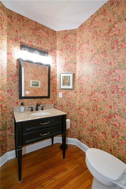 2637 Morningside Trl NW, Kennesaw, GA 30144 - half bathroom featuring wood finished floors, baseboards, vanity, toilet, and wallpapered walls