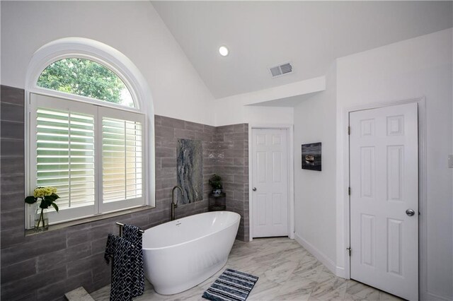 2637 Morningside Trl NW, Kennesaw, GA 30144 - full bathroom featuring a soaking tub, lofted ceiling, marble finish flooring, and tile walls