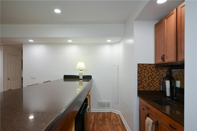 2637 Morningside Trl NW, Kennesaw, GA 30144 - kitchen featuring a sink, dark wood-style floors, recessed lighting, brown cabinets, and dark stone countertops