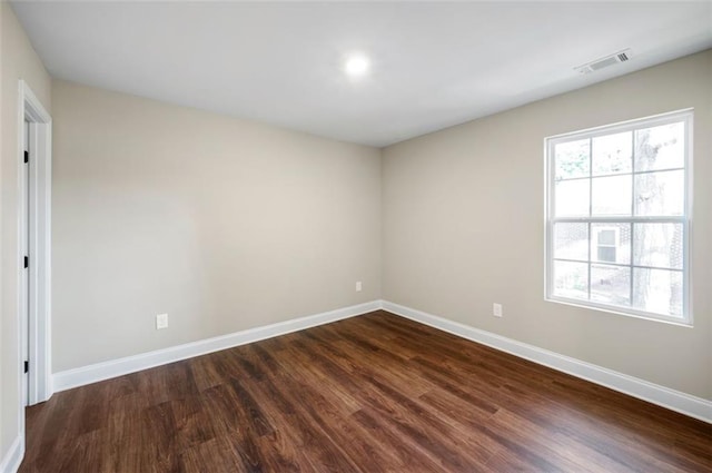 unfurnished room with dark wood-type flooring