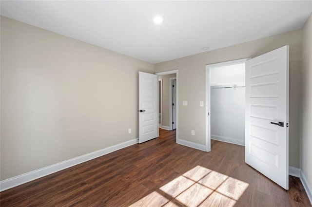 unfurnished bedroom featuring a closet and dark hardwood / wood-style floors