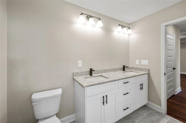 bathroom featuring toilet, hardwood / wood-style floors, and vanity